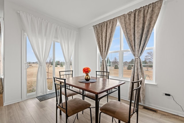 dining room with visible vents, plenty of natural light, and light wood-style flooring