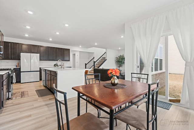 dining room with light wood-type flooring, stairway, and recessed lighting