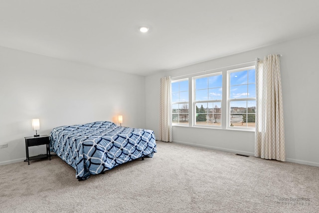 carpeted bedroom featuring visible vents and baseboards