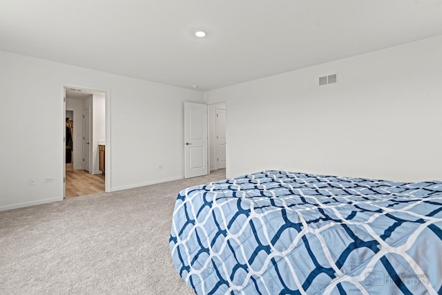 bedroom with light carpet, visible vents, and baseboards