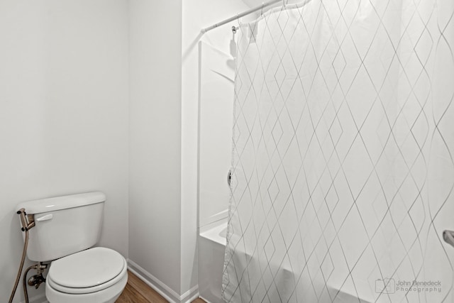 full bath featuring toilet, shower / bathtub combination with curtain, and baseboards