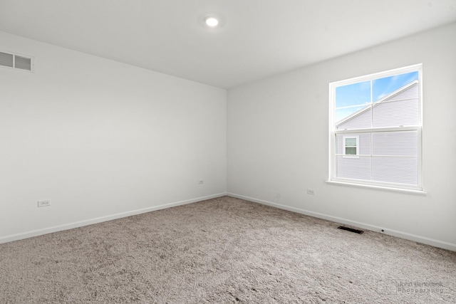 empty room featuring baseboards, visible vents, and carpet flooring