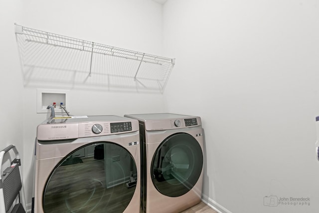 laundry room featuring laundry area, washing machine and clothes dryer, and baseboards