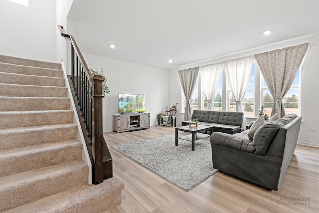 living area featuring recessed lighting, stairway, and light wood finished floors