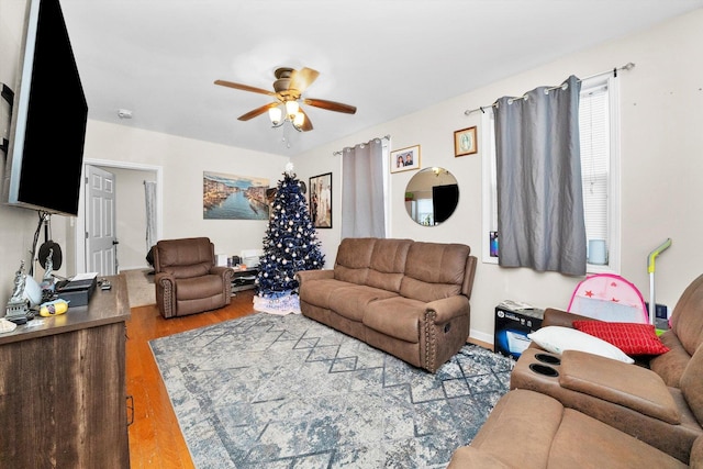 living area with a ceiling fan and wood finished floors