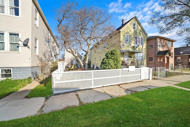 view of side of property featuring a gate, a residential view, fence, and a lawn