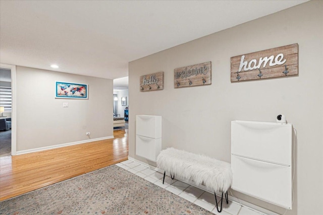 hall featuring recessed lighting, wood finished floors, and baseboards