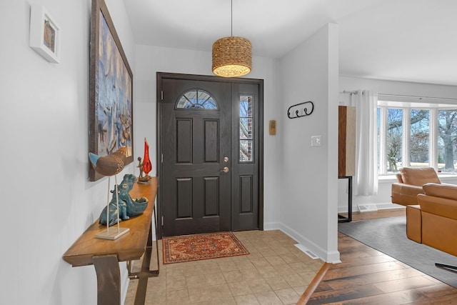 entrance foyer with light wood-type flooring, visible vents, and baseboards