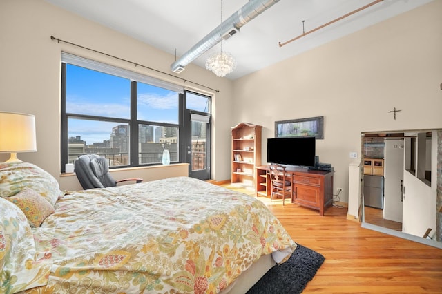 bedroom with wood finished floors, visible vents, and a notable chandelier