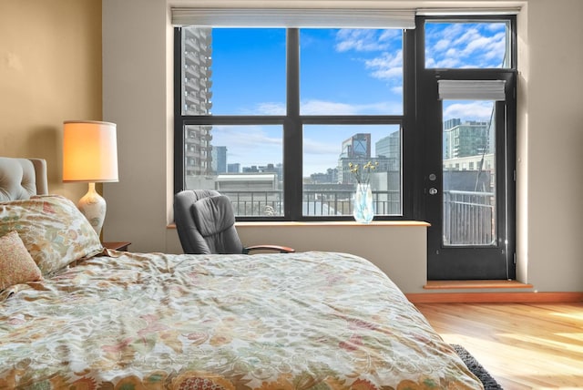 bedroom featuring a view of city and wood finished floors