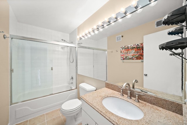 bathroom with visible vents, toilet, shower / bath combination with glass door, tile patterned floors, and vanity