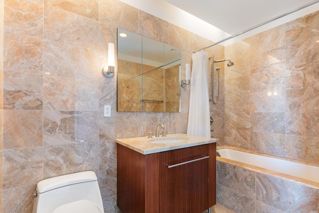 bathroom featuring toilet, tile walls, vanity, and tiled shower / bath