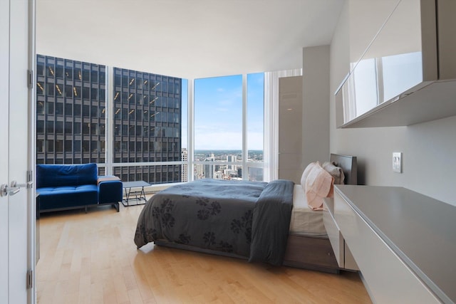 bedroom featuring floor to ceiling windows and wood finished floors