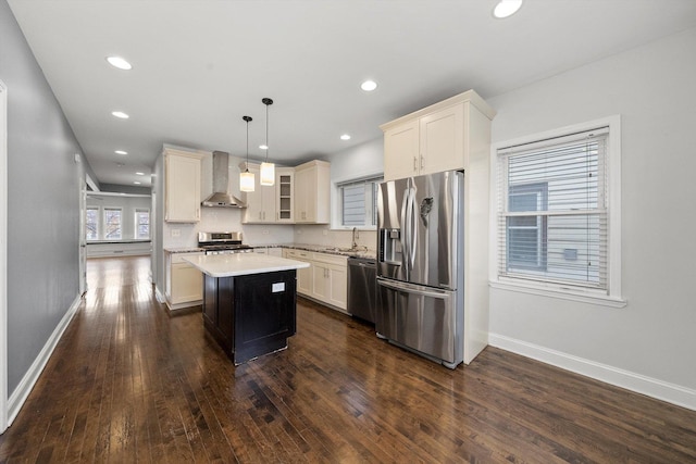 kitchen featuring stainless steel appliances, a kitchen island, light countertops, dark wood-style floors, and wall chimney exhaust hood