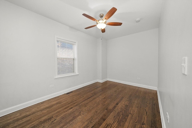 spare room featuring dark wood-style floors, visible vents, ceiling fan, and baseboards