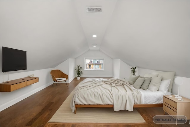 bedroom featuring lofted ceiling, visible vents, baseboards, and wood finished floors