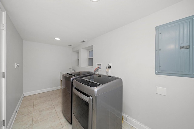 laundry area featuring light tile patterned floors, laundry area, electric panel, independent washer and dryer, and baseboards