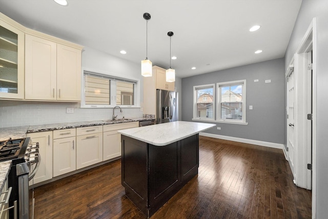 kitchen featuring stainless steel appliances, tasteful backsplash, dark wood-style flooring, and a sink