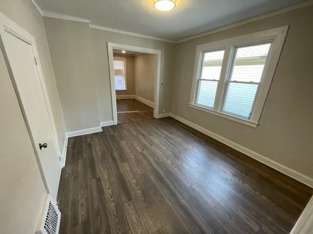 unfurnished bedroom featuring visible vents, baseboards, dark wood finished floors, and crown molding