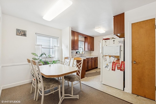 dining area with light carpet and baseboards