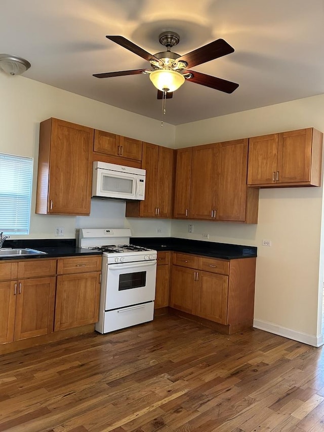 1234 W 49th Pl, Chicago, IL 60609 - kitchen with brown cabinets, a sink, white appliances, ceiling fan, and dark wood-style flooring