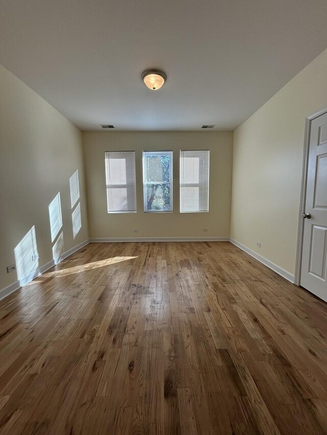 1234 W 49th Pl, Chicago, IL 60609 - unfurnished living room with visible vents, wood finished floors, and baseboards
