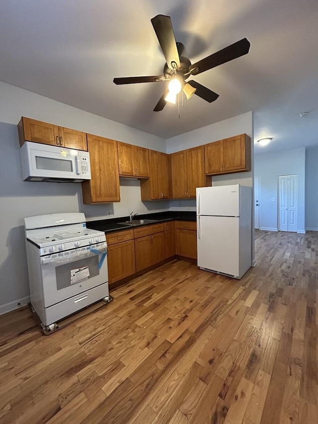 1234 W 49th Pl, Chicago, IL 60609 - kitchen featuring a sink, dark countertops, wood finished floors, white appliances, and ceiling fan