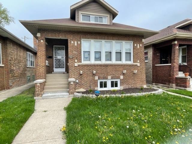 bungalow-style house featuring a front yard and brick siding