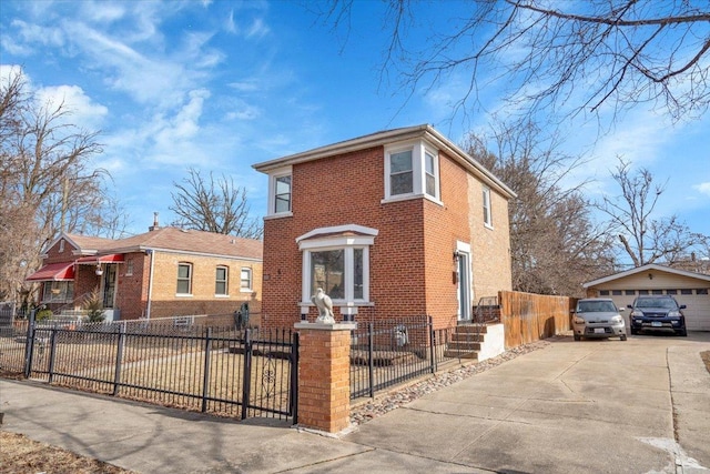 view of front of home with brick siding, a fenced front yard, an outdoor structure, and a detached garage