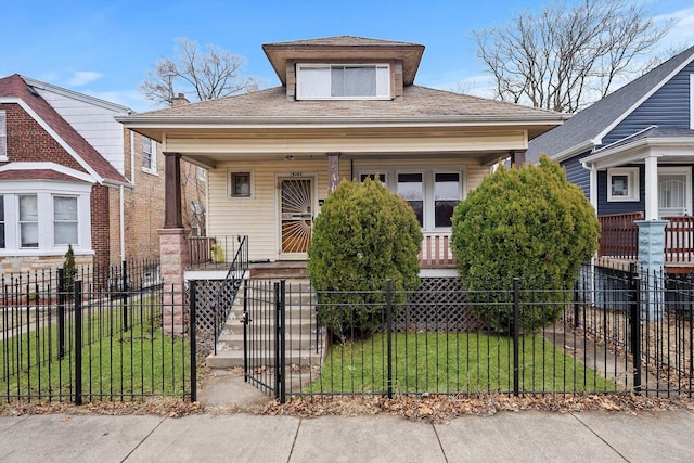 bungalow-style house with covered porch, a fenced front yard, and a front lawn