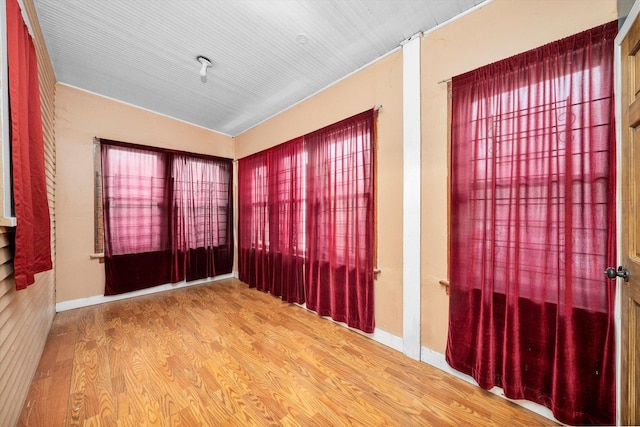 spare room featuring baseboards and wood finished floors