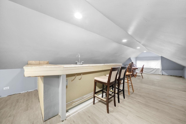 bar with light wood-style flooring, vaulted ceiling, and recessed lighting