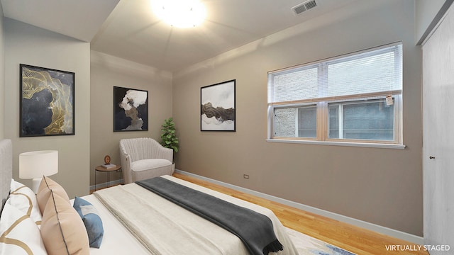 bedroom featuring visible vents, baseboards, and wood finished floors