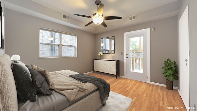 bedroom featuring light wood-style flooring, multiple windows, and visible vents