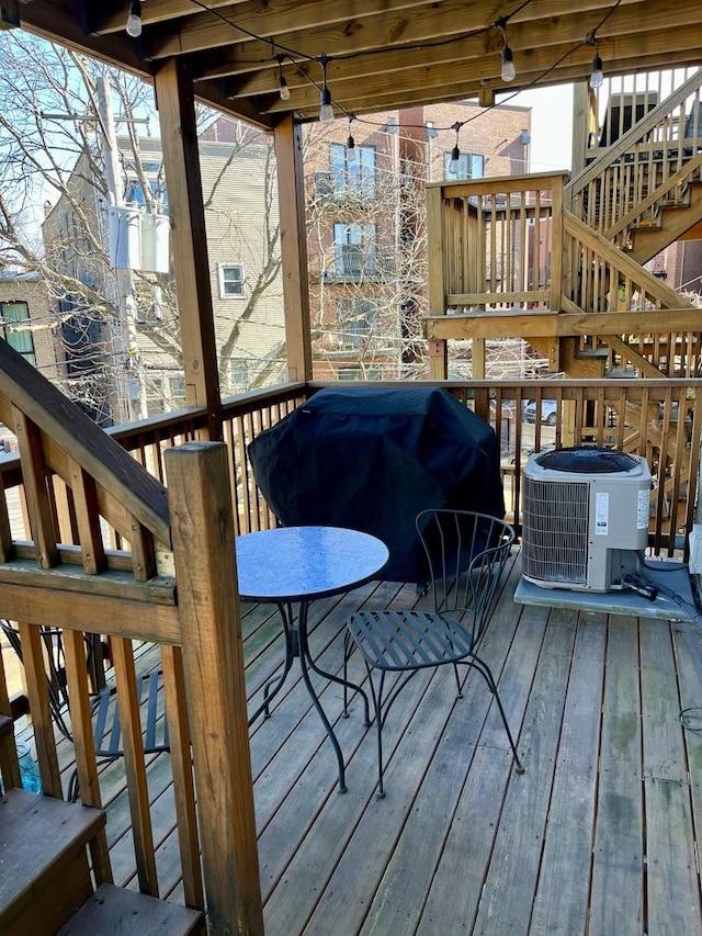 wooden deck featuring central AC unit and grilling area