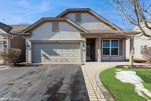 view of front facade featuring aphalt driveway, an attached garage, and a gambrel roof