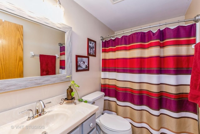 full bath featuring a shower with shower curtain, vanity, and toilet