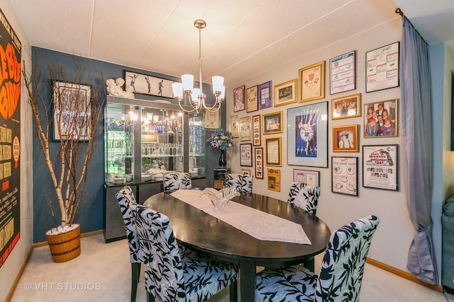 dining room with carpet, baseboards, and a notable chandelier