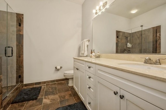 full bathroom with a stall shower, a sink, toilet, and double vanity