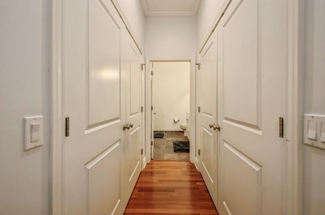 corridor with crown molding and wood finished floors