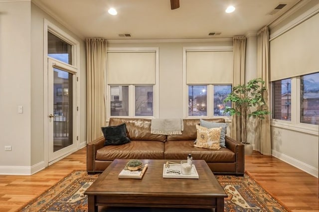 living area with baseboards, visible vents, and wood finished floors