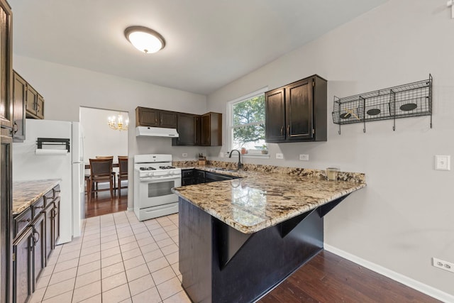2031 Edinburgh Ln, Aurora, IL 60504 - kitchen featuring white appliances, range hood, a peninsula, and light stone countertops