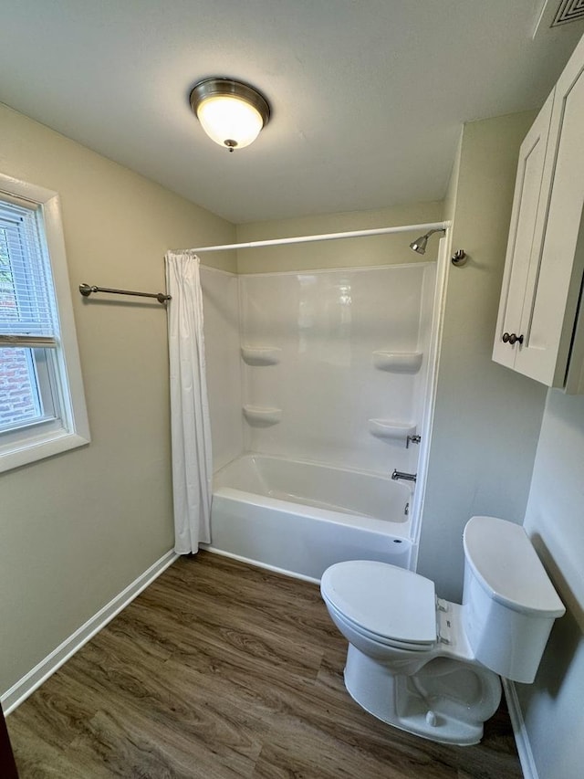 bathroom with baseboards, shower / bath combo with shower curtain, toilet, and wood finished floors