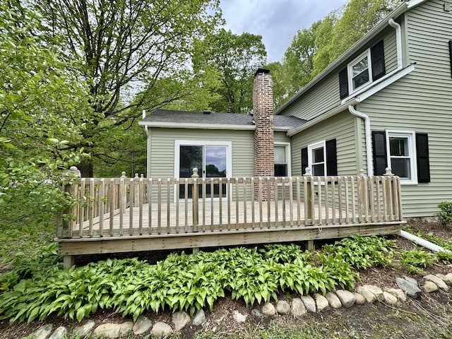 back of house with a chimney and a deck