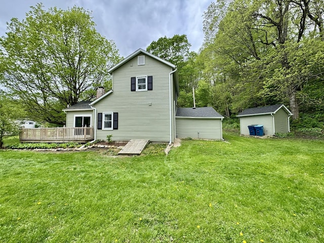 rear view of house featuring a lawn, an outbuilding, a wooden deck, and a storage unit