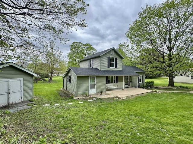 rear view of house with roof with shingles, a shed, a patio area, a lawn, and an outdoor structure
