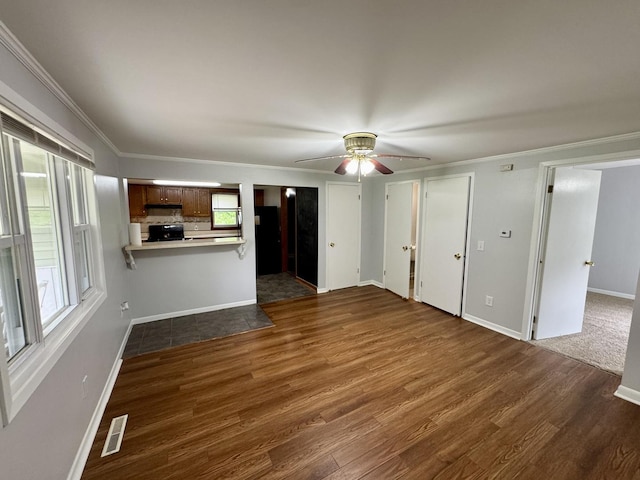 unfurnished living room with visible vents, dark wood-style floors, and a healthy amount of sunlight