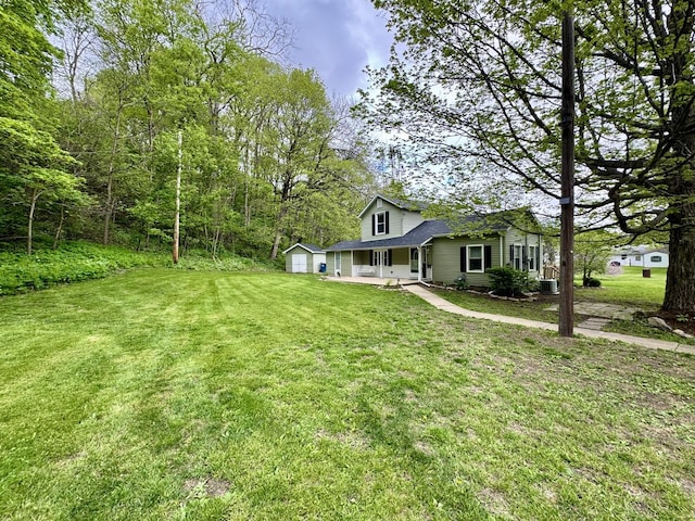 view of yard featuring covered porch and a detached garage