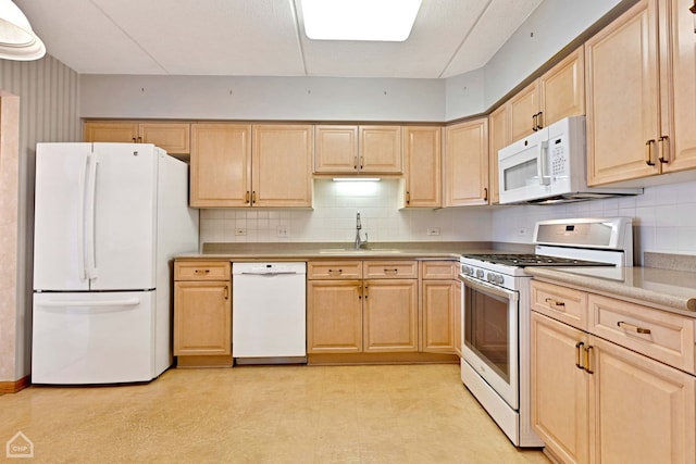 kitchen with white appliances, a sink, light floors, and light brown cabinetry