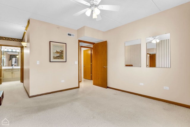 unfurnished room featuring baseboards, visible vents, a ceiling fan, and light colored carpet